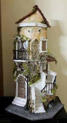 a doll house made out of clay and fake plants