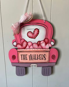 a pink sign hanging from the side of a wall with hearts on it that says, the walkers