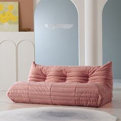 a pink couch sitting on top of a white rug