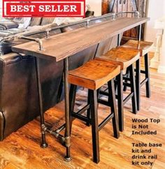 three stools sit at the end of a table in front of a leather couch