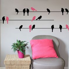 the birds are sitting on the wire wall decals in this room, and one is pink