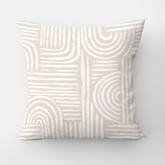 a beige and white pillow with an abstract design on the front, featuring wavy lines