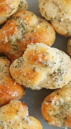 small rolls covered in cheese and herbs on a plate