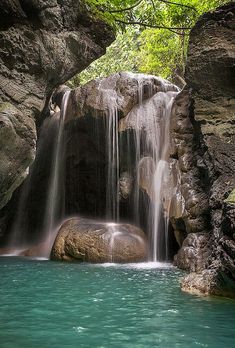 a waterfall is coming down into the water