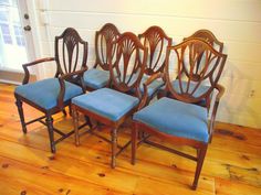 six chairs with blue upholstered seats are lined up in a row on the floor