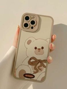 a person holding up an iphone case with a bear on the front and bottom cover