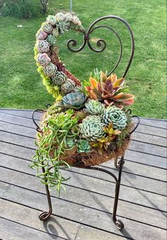 a heart shaped planter with succulents in it on a wooden deck