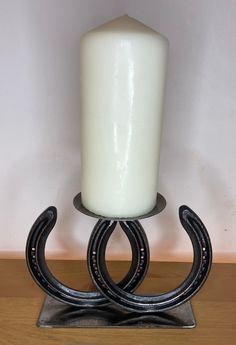 a white candle sitting on top of a metal stand