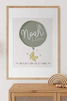 a framed poster with the words noah and an elephant on it in front of a wooden cabinet