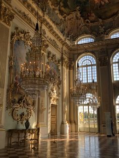 an ornate room with chandeliers and paintings on the walls