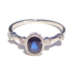 This Darling ring has a Natural, faceted, oval cut, 1.00ctw Genuine Blue Sapphire, (mined, not lab created, with four tiny, 1.5mm, faceted, Genuine Diamonds on the band. The Sapphire is SI color, and 7.40mm North to South. The hight above the finger is 4.85mm, shank width is 1.30mm, and gram weight is 1.8g. The .07ctw Diamonds are round, with I color, and SI Clarity. The ring is .925 Sterling Silver, in a size 7, resizable by your local silver smith or jeweler, if need be. This little Beauty wou Oval Sapphire Ring With Rose Cut Diamonds For Promise, Oval Sapphire Ring With Rose Cut Diamonds, Blue Oval Birthstone Ring With Diamond Accents, Oval Sapphire Promise Ring With Ethical Diamonds, Oval Sapphire Ring With Bezel Setting, Oval Sapphire Diamond Ring With Rose Cut Diamonds, Oval Rose Cut Diamond Ring In Sterling Silver, Oval Sapphire Diamond Ring With Bezel Setting, Oval Diamond Birthstone Ring With Bezel Setting