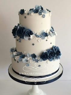 a three tiered cake with blue flowers on it