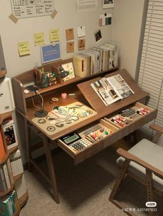 a computer desk with many books and papers on it in an office space next to a book shelf