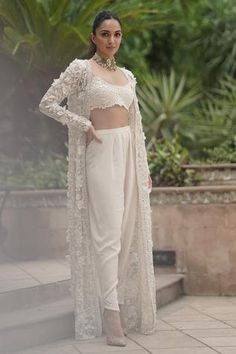 Ivory open-front jacket with beads, pearls and 3D floral embellishment. Comes with sleeveless crop top and co-ordinating crepe pants.
Components:3
Pattern:Embellishment
Type of Work:Pearl, Beads and 3D floral motifs
Neckline:Round
Sleeve Length:Jacket: Full and Crop Top: Sleeveless
Fabric:Organza and Crepe
Color:White
Other Details:
Crop top with bead drops
Pleated pants with embellished hems
Open front cape
Occasion:Destination Wedding - Aza Fashions Indian Outfits Modern, Trendy Outfits Indian, Indian Outfits Lehenga, Gaun Fashion, Traditional Indian Dress, Indian Dresses Traditional, Traditional Indian Outfits, Kiara Advani, Designer Dresses Casual