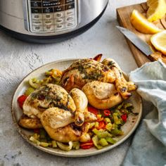 a plate with chicken and vegetables next to an instant pot roaster