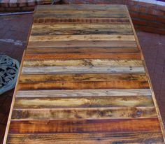 a wooden table sitting on top of a brick sidewalk