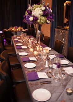 a long table is set with purple and white flowers