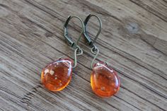 Orange Earrings, Dangle Drop Earrings, Glass Earrings, Teardrop Earrings, Orange Jewelry, Gift for women, Gift for her  Lovely, dangling earrings made of juicy orange with gold spots Czech glass teardrop. Handmade swirl in brass tone wire, hanging from lever-back antique brass tone ear wires ( lead and nickel free). Color :  Orange Briolette Beads Czech Glass Beads Teardrops Tear Drops SUNSHINE DUST Top Side Drilled Briolettes 16mm x 12mm Pressed Glass Finish : Antique Brass findings Size : Approx 1,5 inches including the antique brass lever back Ear wires : Antique brass lever back Your pair of earrings will arrive carefully packed in a kraft box jewelry with ribbon, perfect for gift giving to a loved one...or to yourself. Czech Glass Earrings : https://www.etsy.com/shop/NtikArtJewelry?re Handmade Orange Teardrop Earrings, Handmade Orange Teardrop Earrings For Gift, Orange Teardrop Earrings As Gift, Unique Drop Earrings, Small Drop Earrings, Small Dangle Earrings, Orange Jewelry, Orange Earrings, Fall Earrings