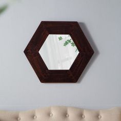 a mirror hanging on the wall above a couch