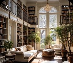 a living room filled with lots of furniture and bookshelves next to a window