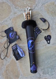 an assortment of items are laid out on a stone floor, including a black umbrella and other accessories