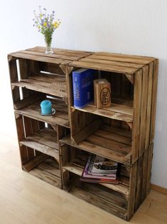 a wooden shelf with books on top of it next to a vase filled with flowers