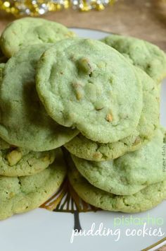 green cookies stacked on top of each other on a white plate with gold confetti in the background