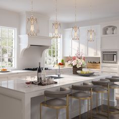 a large kitchen with white cabinets and counter tops, an island with four stools