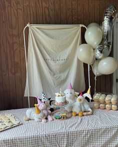 a table topped with lots of cupcakes and balloons