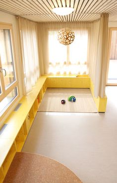 an empty room with yellow furniture and windows