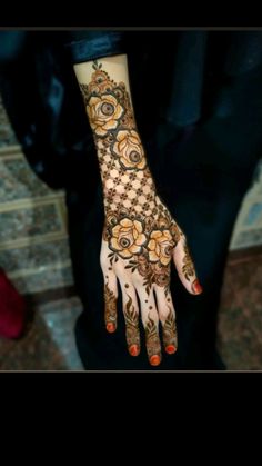 a woman's hand is decorated with hennap and orange flowers on it