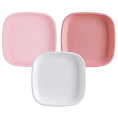 three pink and white plates sitting next to each other