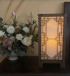 a vase filled with flowers next to a lit candle