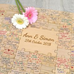 a wooden puzzle with two flowers on it and wedding date written on the front side