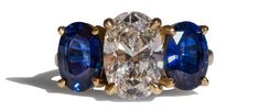 three stone ring with blue and white stones on each side, set in yellow gold plating