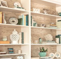 a white book shelf filled with lots of books and knick - knacks