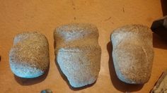 three rocks sitting on top of a wooden table next to a pair of shoes and an object