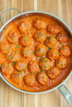 meatballs and sauce in a pan on a wooden table