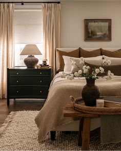 a bedroom with a bed, dresser and table in it's centerpieces