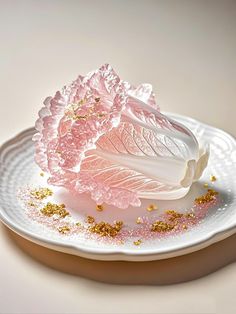 a white plate topped with pink and gold sprinkles next to a piece of broccoli