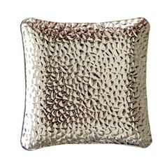 a silver pillow that is on a white background and has small circles in the middle