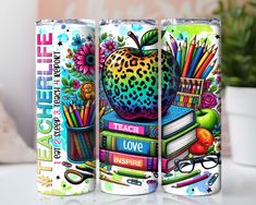 two cans with colorful artwork on them sitting next to a potted plant and books