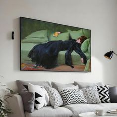 a living room filled with furniture and a painting hanging on the wall over a white couch