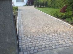 the driveway is made of bricks and gravel