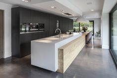 a modern kitchen with an island countertop and stainless steel appliances in the middle of the room