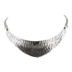 This is part of Chairish’s Costume Jewelry assortment.  Rhodium plated textured bib necklace with spring ring clasp. Unmarked but matching cuff (sold separately) is marked. Circa 1976 or 77 based on similarly styled bracelets and necklaces advertised in those years. Measures: 6 inches long by 4 1/4 inches wide. Center; 1 inch. Excellent condition.  Color: silver  Please reference the measurements noted in the description above for the best approximate dimensions. Please reach out to the seller u Metal Choker Bib Necklace In Costume Jewelry Style, Metal Choker Bib Necklaces For Costume Jewelry, Silver Bib Necklace In Costume Jewelry Style, Elegant Metal Choker With Oxidized Finish, Silver Bib Necklace Choker In Costume Style, Elegant Adjustable Oxidized Choker, Silver Metal Formal Choker, Elegant Hammered Choker Jewelry, Elegant Metal Choker