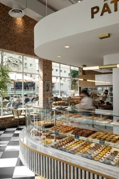 a bakery filled with lots of donuts and pastries next to a checkered floor