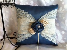 a blue pillow with lace and flowers on it sitting next to a black wire rack