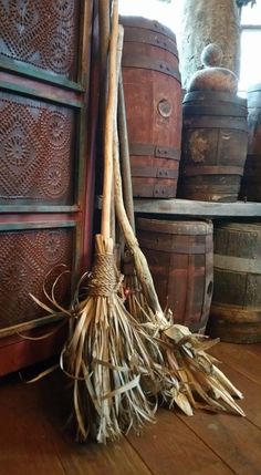 a broom sitting on top of a wooden floor next to barrels