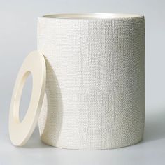 a roll of toilet paper sitting next to a roll of tape on a white surface